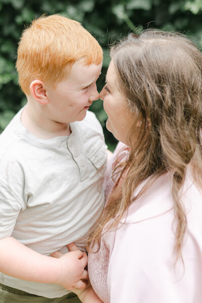 Redhead boy giving his mom eskimo kisses.