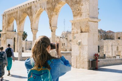 Woman_taking_picture_of_ruins_Israel_travel_concierge