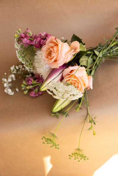Soft peach roses and lilies arranged on craft paper