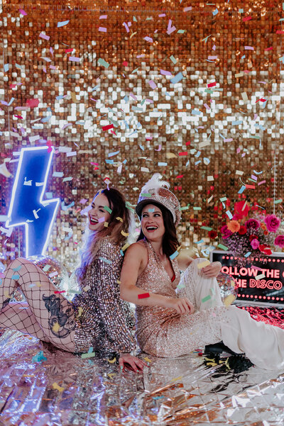A same sex couple at The Canary Shed in Essex at their disco themed wedding. 