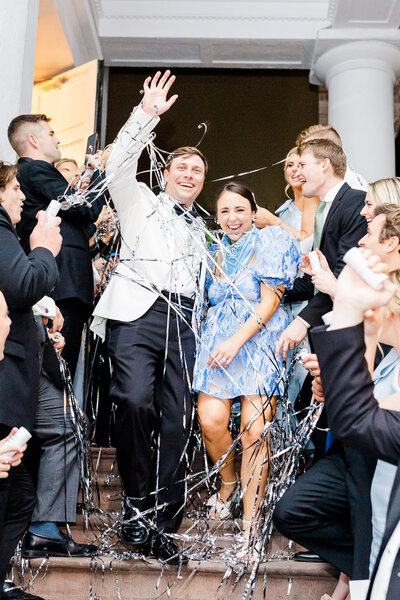 bride and groom getting sprayed with confetti at wedding reception