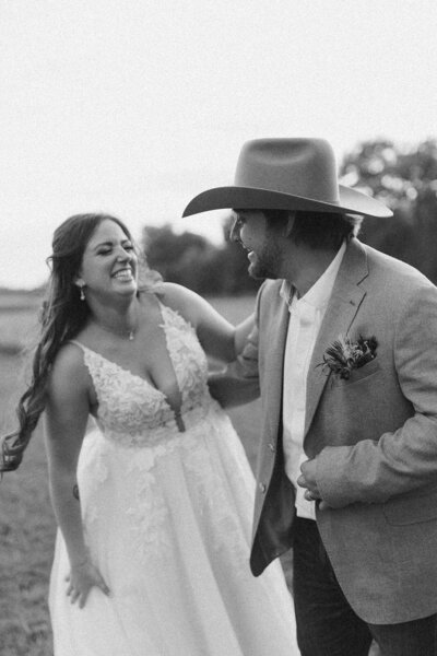 bride and groom share a sweet moment laughing and having fun on their wedding day at the vintage fields in madison wisconsin