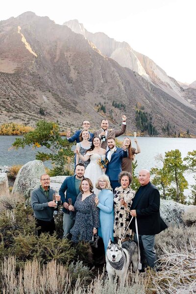 A small group of family and friends raise a glass to the bride and groom moments after their wedding at convict lake.