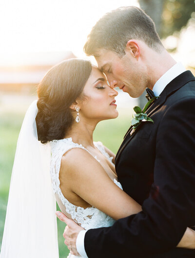 Bride and groom with eyes closed and foreheads together