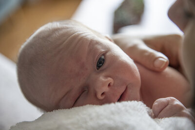 Sleepy baby looking at camera.
