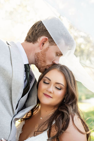 Groom kissing bride forehead at Raleigh wedding