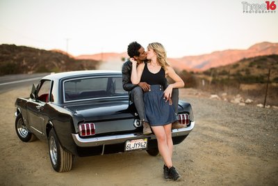 Groom to be sits on his Mustang and kisses his Bride in Red Rock Canyon in Silverado
