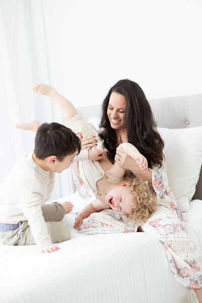 NH Newborn Photographer Kathleen Jablonski captures moment between a mama and her two sons as they play silly by tickling eachother