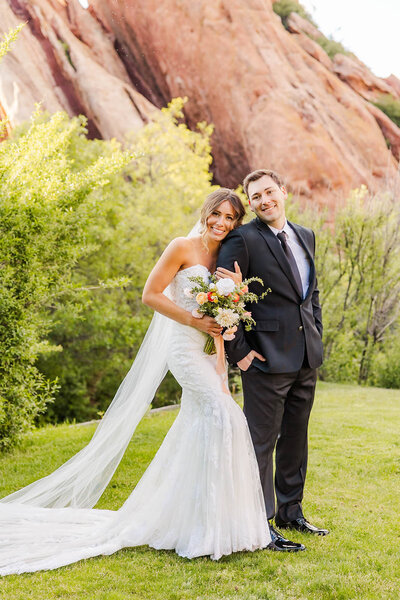 Bride and groom standing next to each other at their wedding in Littleton, Colorado at the Arrowhead Golf Course featuring beautiful colorful bouquet.
