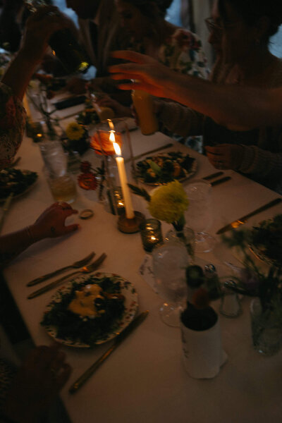 A table scape lit by candles at a wedding reception