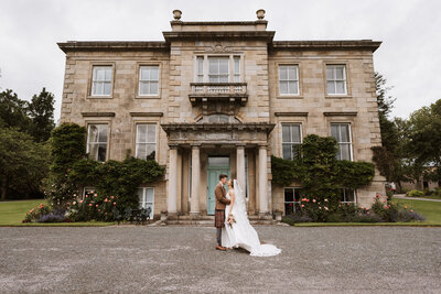 Bride and bridesmaids laughing under confetti at aswanley wedding venue