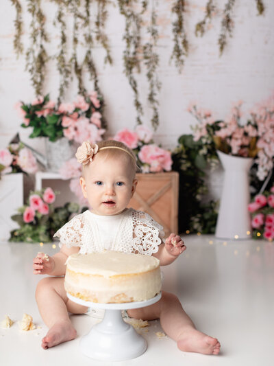 photo of one year girl eating cake