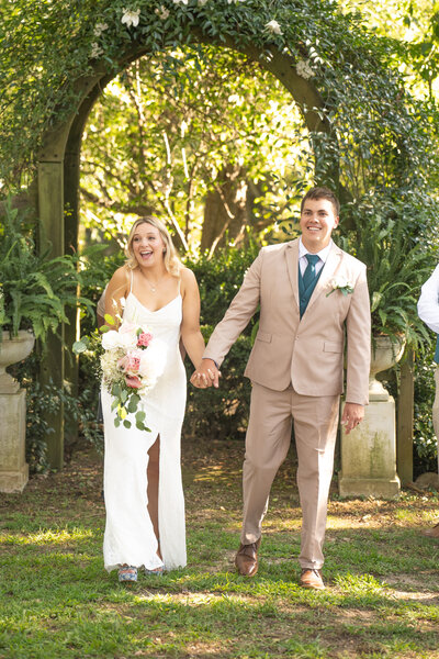 Bride and groom walking down the isle after they kiss and say I do at  Historic Tuckahoe in Richmond, VA.