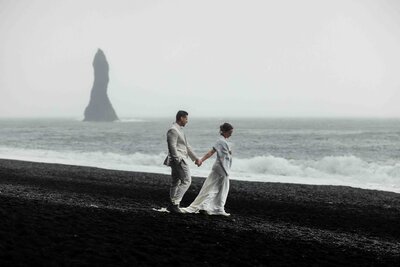 walking down the black sand beach in Iceland for an elopement photoshoot