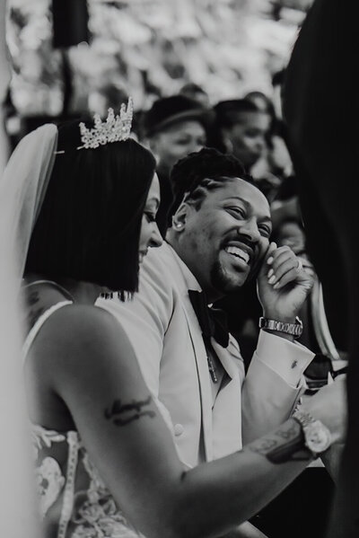 a couple laughing while listening to the best man's toast during their reception 