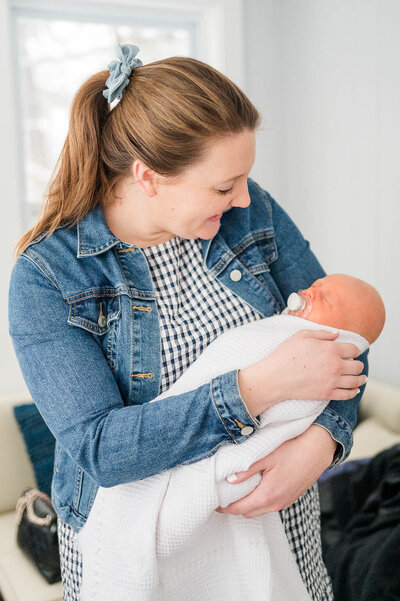 Best newborn photographer in Central MA holding baby