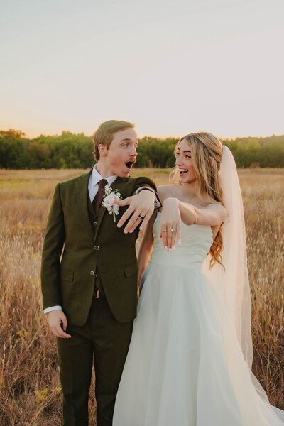 bride and groom showing off rings at wedding in oklahoma city