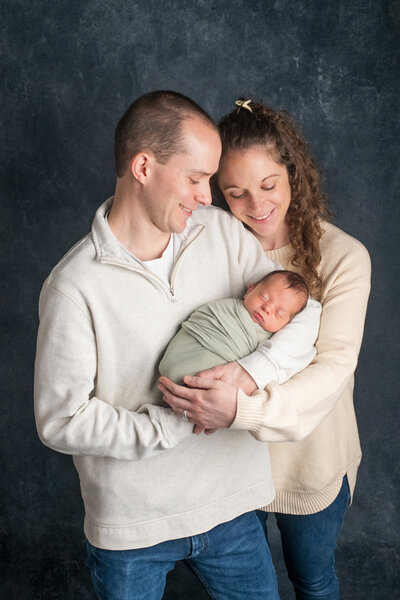 Happy husband and wife holding newborn baby boy