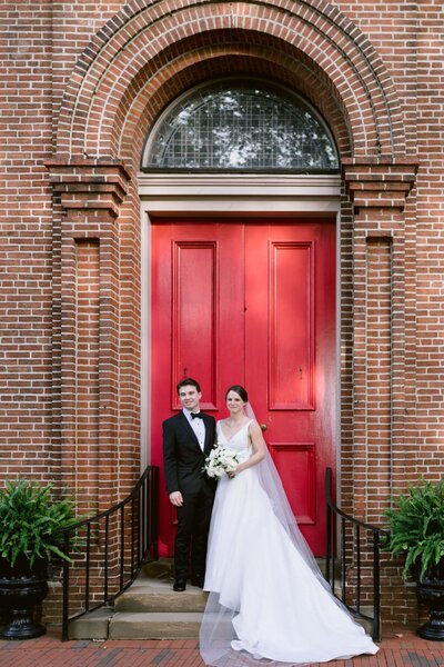 Bride and groom in front of red door