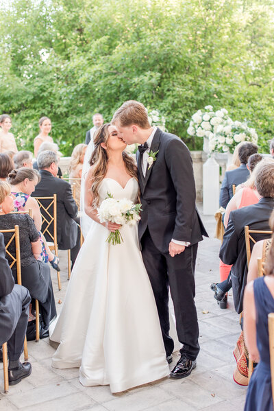 couple kissing at wedding ceremony recessional