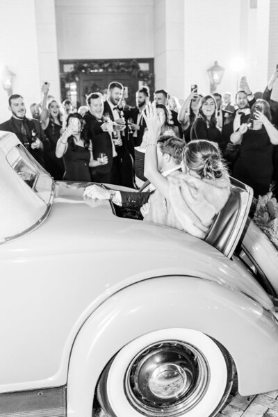 bride and groom leaving wedding in a vintage car