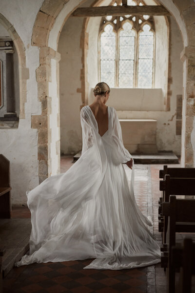 Deep v back georgette silk flowing wedding dress on bride at church wedding