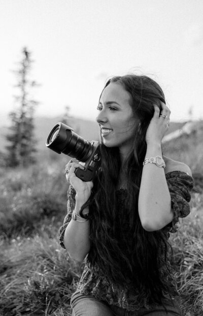 Black and white photo of Aurelia from Aurelia K Photography, smiling and looking away from the camera.	