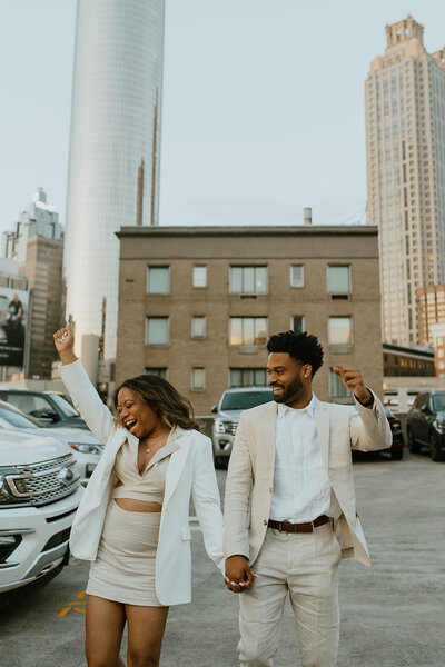couple cheers during engagement photos in downtown Atlanta