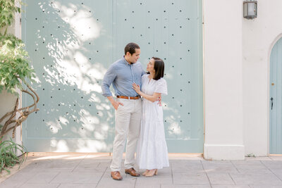an engaged couple posing for a photo with blue and white coastal vibes
