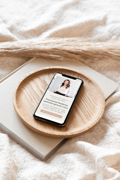 Iphone on wood tray open to functional medicine provider website