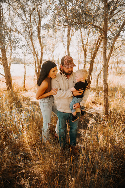 While soaking in the simple and fun family session near Sweet Briar Lake, ND a momma plays peek-a-boo with her little one. 