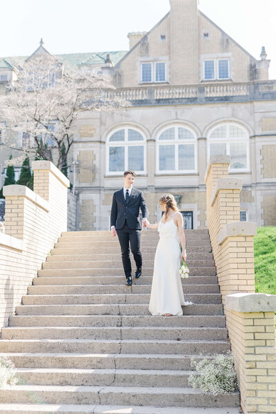 Man escorts woman down the stairs of a beautiful and luxurious wedding venue in Indiana