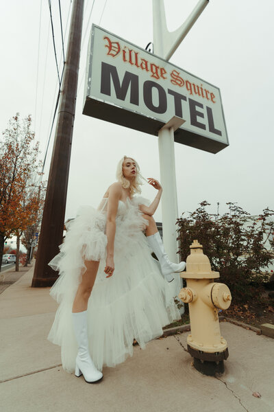 cool bride standing by a hotel sign