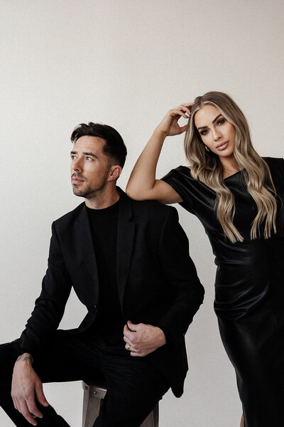 Close-up editorial portrait of luxury wedding photographers embracing, showcasing their sophisticated brand and artistic vision for high-end destination weddings.