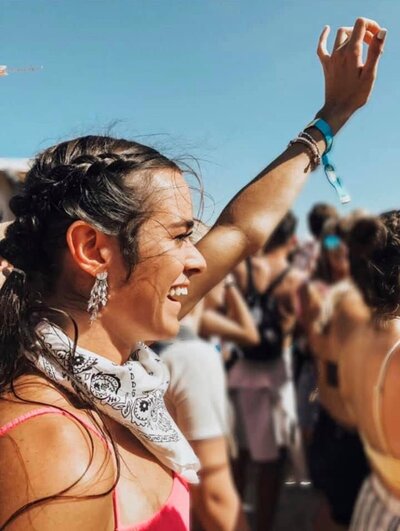 dark haired girl raising her hand smiling
