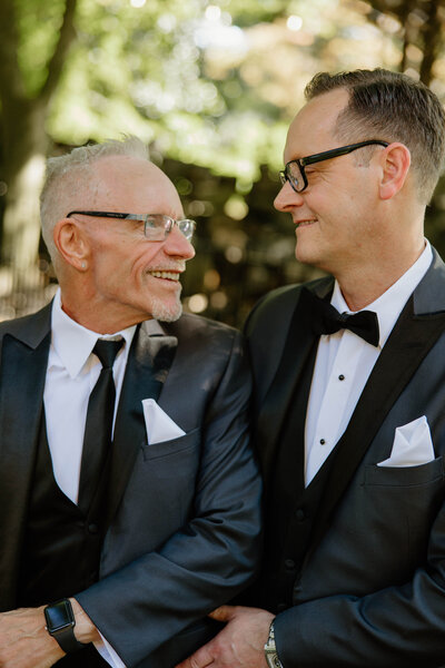 Same sex couple embracing on their wedding day