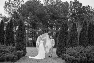 Bride underneath her veil while groom is looking at her — Madison Abernathy Photo