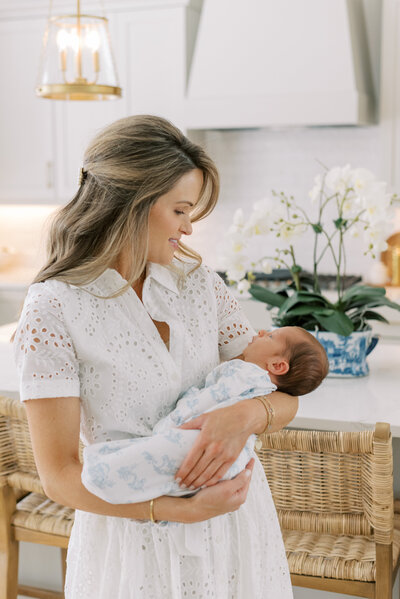 Mother holding newborn baby in the kitchen