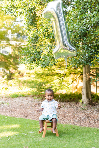 One year old child holding a balloon