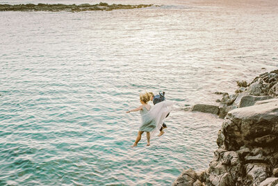 newly maried couple jumping of a cliff into the sea on Maui by portland photographer Mariah Milan