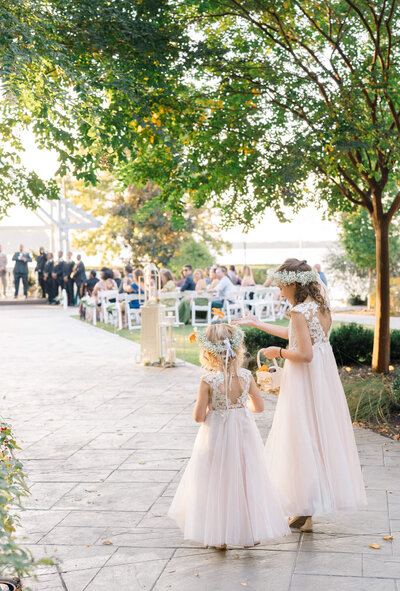 Flower girls throwing flowers during the wedding processional at The Boathouse at Sunday Park. Captured by Charlottesville Wedding Photographer Bethany Aubre Photography.