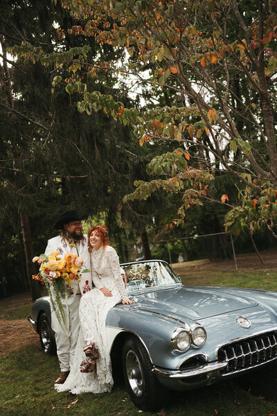 bride and groom sitting on vintage car