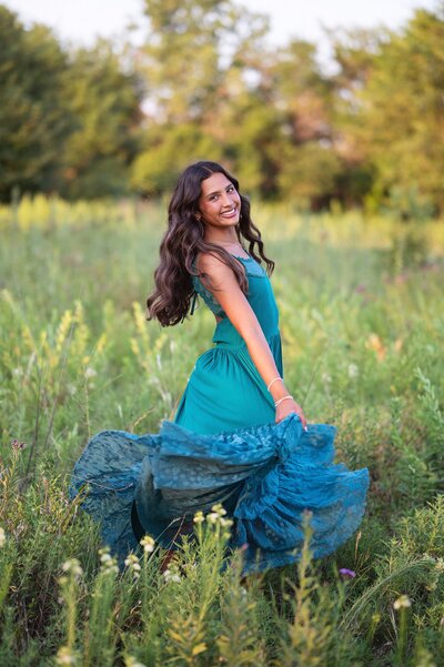 picture of high school senior girl in a field of zinnias wearing a pink dress