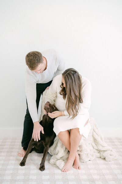 Pregnant woman with her husband and chocolate lab