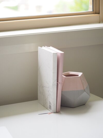 white-and-pink-books-piled-beside-pink-and-gray-ceramic-vase-749569