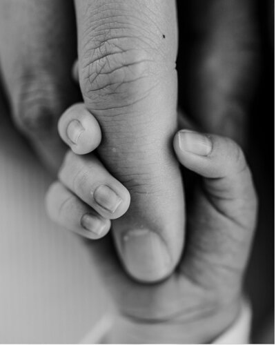 Tiny newborn fingers holding moms hand during his Navarre newborn session