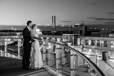 newlyweds look over balcony