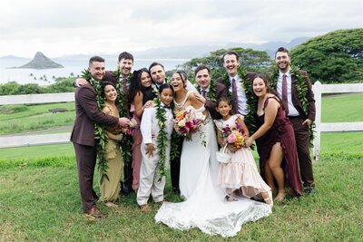 Newlyweds smiling and laughing with their wedding parties 