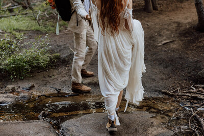 bride and groom crossing a stream close up of boots