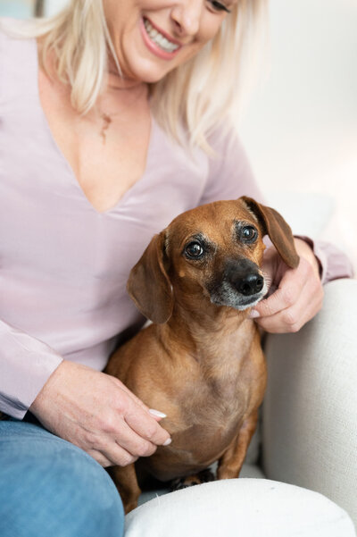 woman sitting on couch with small dog